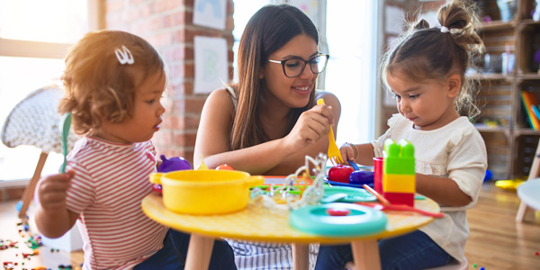 A woman plays with two children