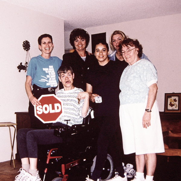 Mary Ellen Sousa (far left) and staff helped Chris (holding keys) become a homeowner in 2000.
