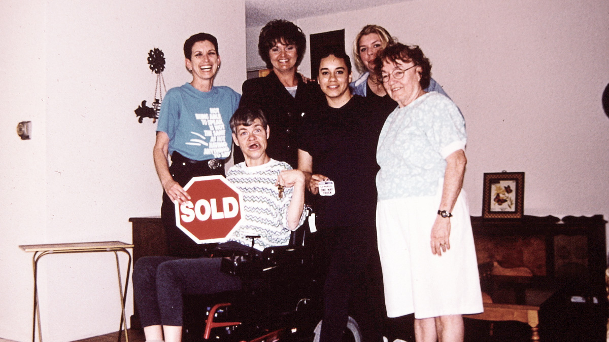 Mary Ellen Sousa (far left) and staff helped Chris (holding keys) become a homeowner in 2000.
