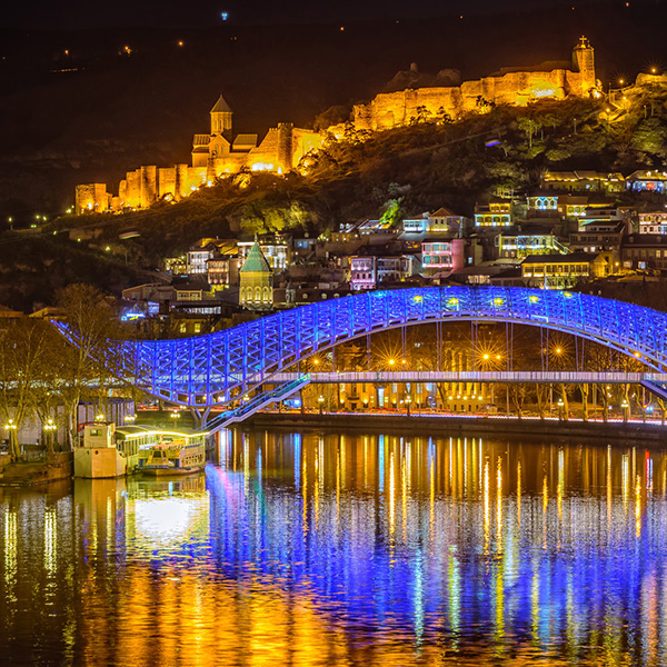 The Bridge of Peace in Tbilisi, Georgia, illuminated at night.