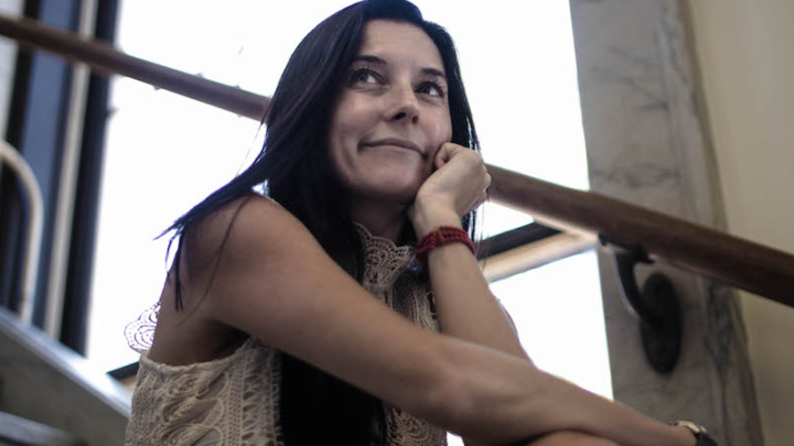 Emily Vizzo smiles while sitting on a staircase.