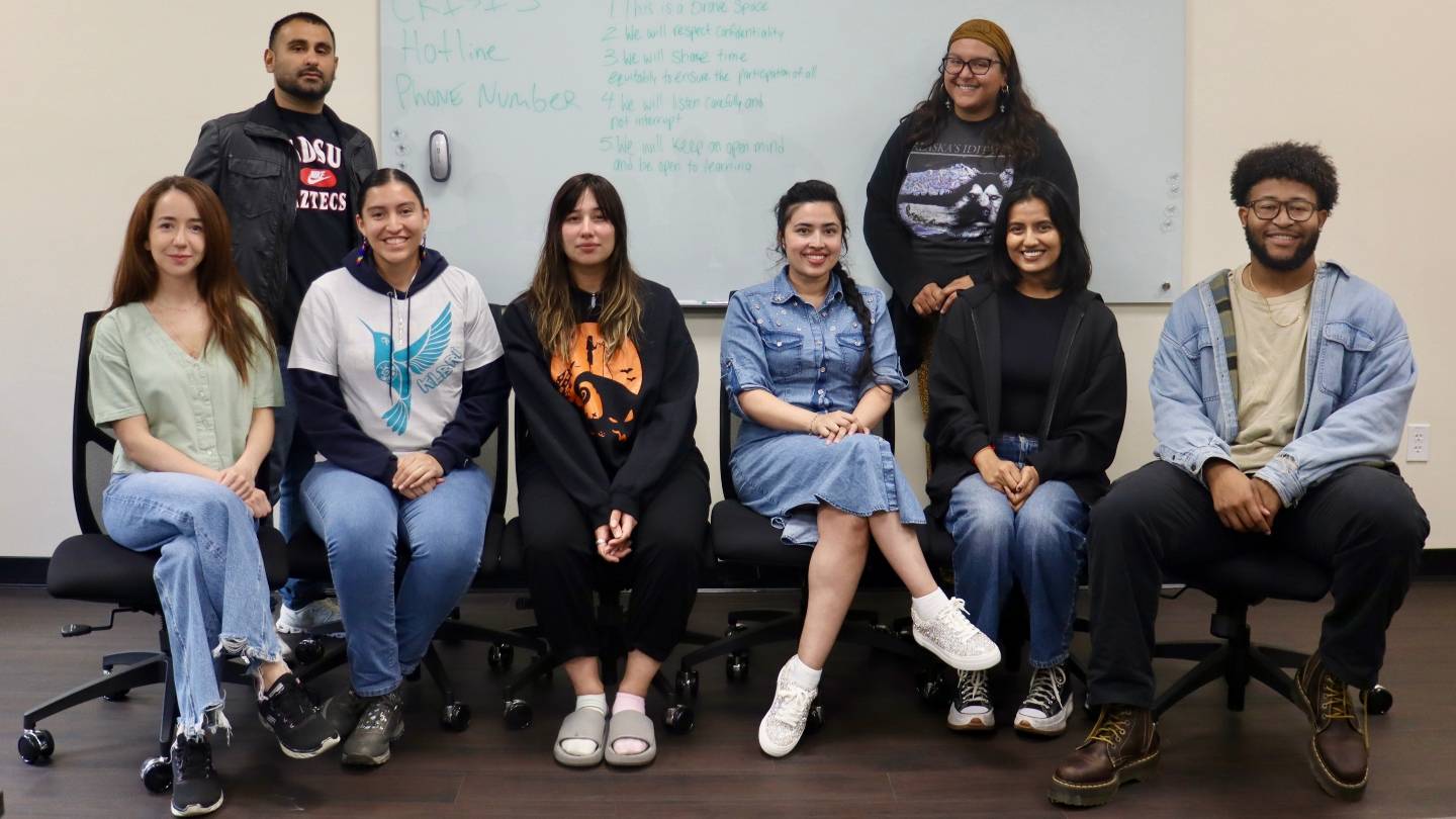 Eight students gather in a conference room.