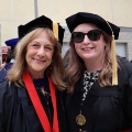 A graduate student from the Class of 2025 and a faculty member celebrate outside Viejas Arena. 