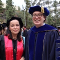 A graduate student from the Class of 2025 and a faculty member celebrate outside Viejas Arena. 