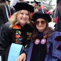 A graduate student from the Class of 2025 and a faculty member celebrate outside Viejas Arena. 