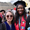 A graduate student from the Class of 2025 and a faculty member celebrate outside Viejas Arena. 